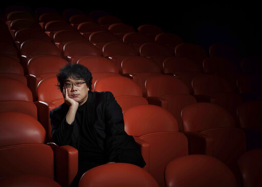 This Oct. 8, 2019 photo shows filmmaker Bong Joon-Ho posing for a portrait at the Whitby Hotel screening room in New York to promote his film Parasite.  The film will open in theaters Friday having already amassed $70.9 million in Bongs native South Korea. In May, Parasite won the Palme d’Or at the Cannes Film Festival, a first for a Korean film. (Photo by Christopher Smith/Invision/AP)