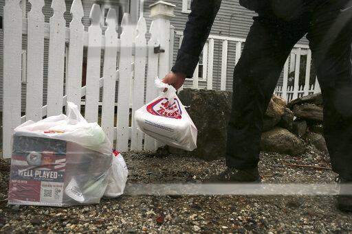 Photo courtesy of AP Images. Instacart worker leaves groceries at the gate of a home in East Derry, N.H.