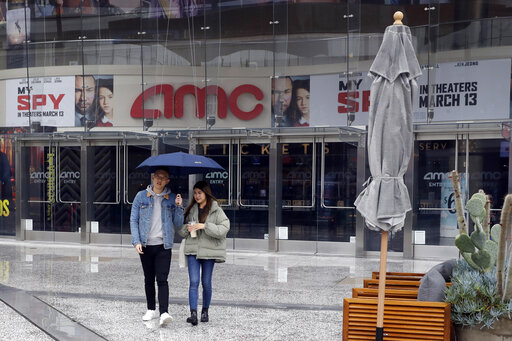 People exit an AMC theater March 14, 2020, in Los Angeles. Californians wanting to escape the new reality of the coronavirus at the movies, casino or amusement park are running into the six-foot rule. State health officials issued new guidance Saturday urging theaters to keep attendance under 250 people and ask strangers to sit six feet apart. (AP Photo/Marcio Jose Sanchez)