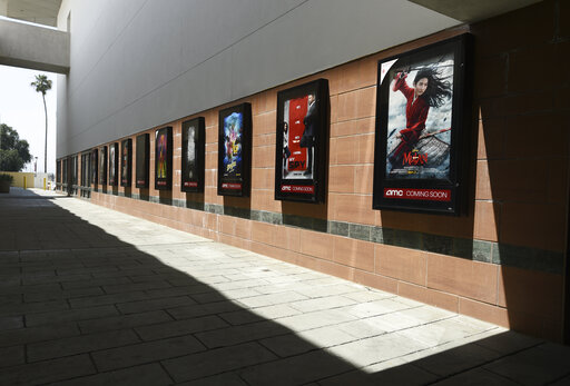 Posters for upcoming movies are displayed in an empty corridor at the currently closed AMC Burbank Town Center 8 movie theaters complex, Wednesday, April 29, 2020, in Burbank, Calif. (AP Photo/Chris Pizzello)