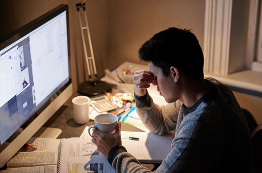 A young student studies for an exam late at night