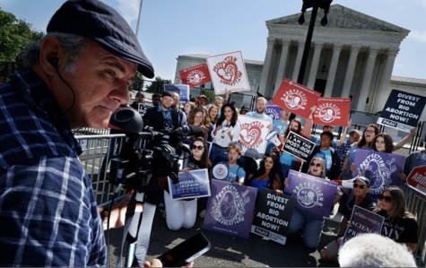 Photo courtesy Chip Somodevilla/Getty Images. Anti-abortion demonstrators pose for photographs outside the U.S. Supreme Court building after rallying against the landmark Roe v. Wade abortion decision on May 23, 2022 in Washington, DC. 