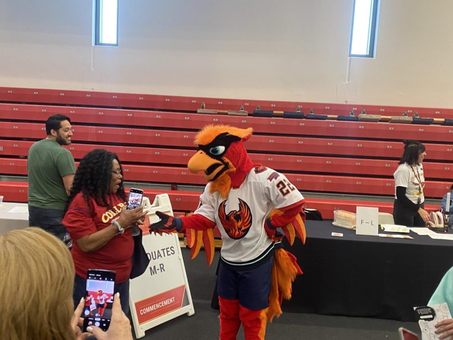 Fuego the Firebird interacting with COD faculty at GradFest