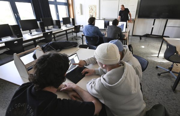 Photo courtesy of AP Images/Bernd Weissbrod. Trainees work on computers in a classroom at the vocational school for wood technology.