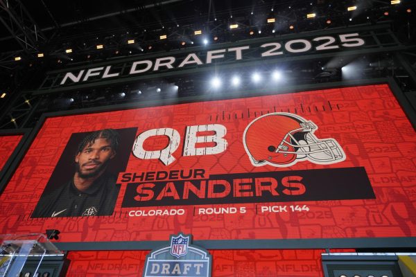 Photo courtesy of (AP Photo/Jeff Roberson). A graphic is shown after the Cleveland Browns select Shedeur Sanders in round 5 on Day 3 of the 2025 NFL Draft on Saturday, April 26, 2025 in Green Bay. 