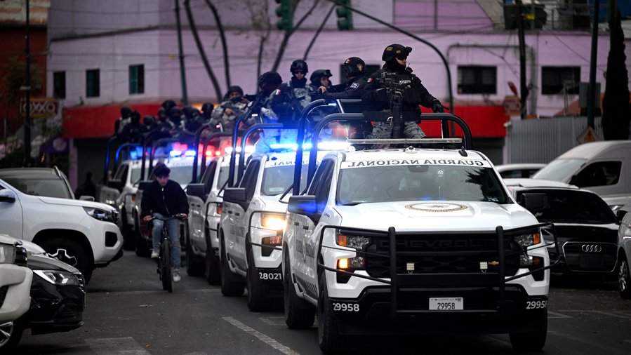 Photo Courtesy of Alfredo Estrella/Agence France-Presse — Getty Images. National guard is seen entering Mexico's capital.