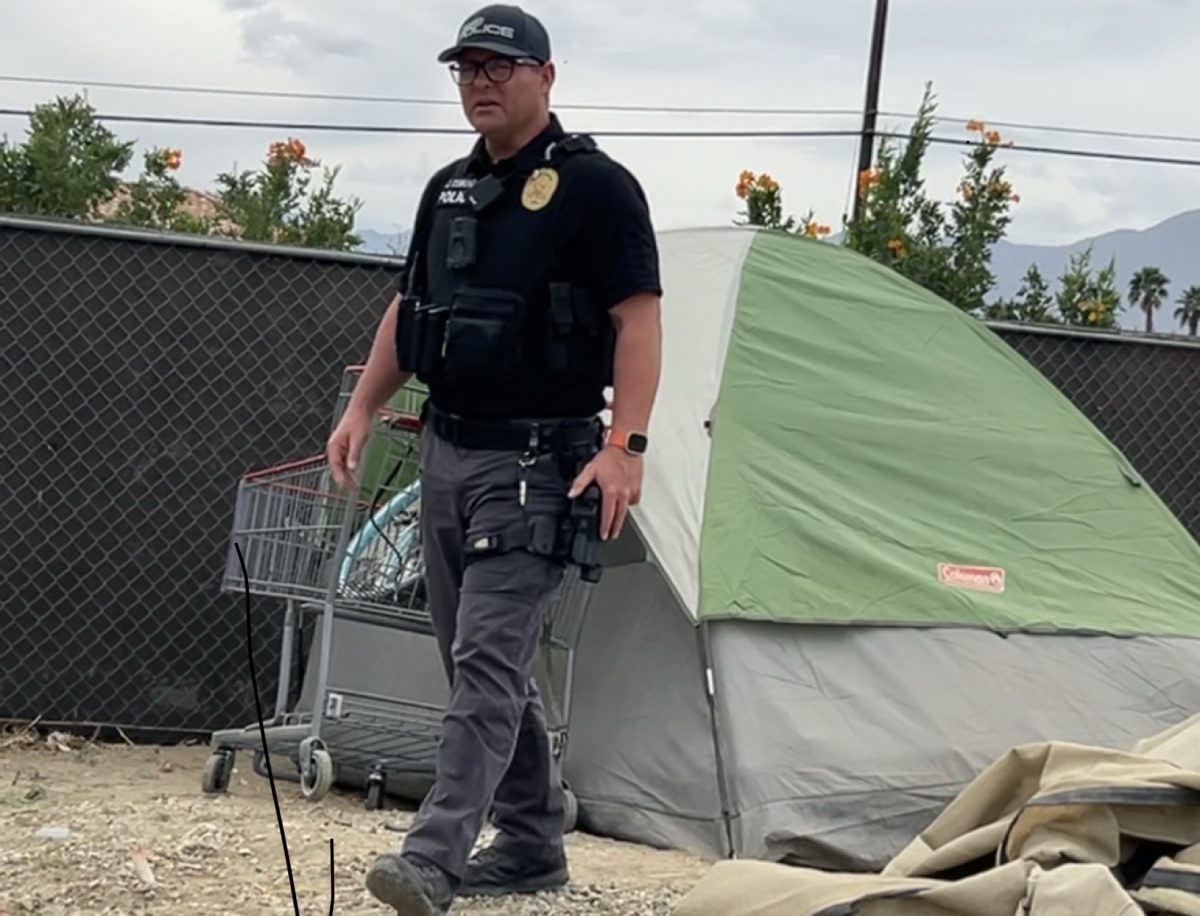Photo courtesy of The Chaparral. Indio Police officer pictured during homeless encampment sweep on February 11 2026.