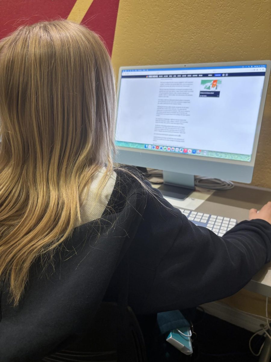 Photo courtesy of The Chaparral/Keira Davidson.Student reading news article