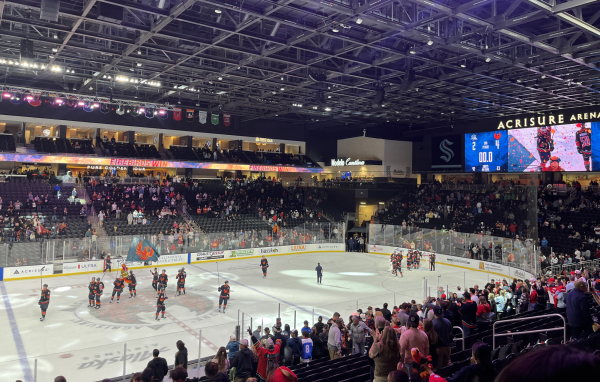 The Firebirds skate across the ice with their sticks in the air, and the mascot waves a large Firebrids flag. The screen shows the game has ended with a score of 4 Firebirds - 2 San Jose.