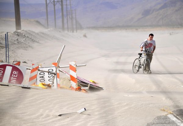Photo courtesy of AP/Josh Edelson. Drew Smith walks his bike along a closed stretch of Indian Canyon Drive in Palm Springs, Calif., Sunday, May 29, 2011. Strong winds ripped through the Coachella Valley on Sunday bringing gusts of up to 65mph and forcing the closure of two main roads through Tuesday.